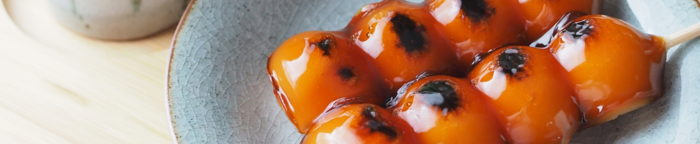 画像：お皿にのった二本のみたらし団子